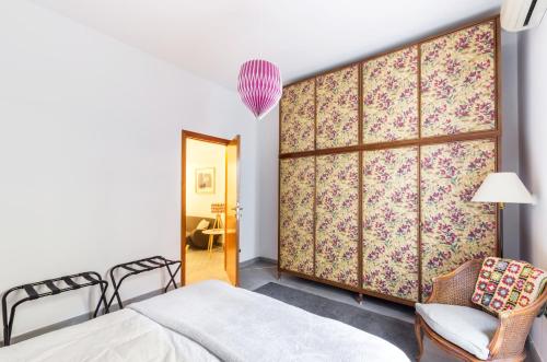 ローマにあるMonteverde lovely flatのベッド1台、椅子、鏡が備わる客室です。