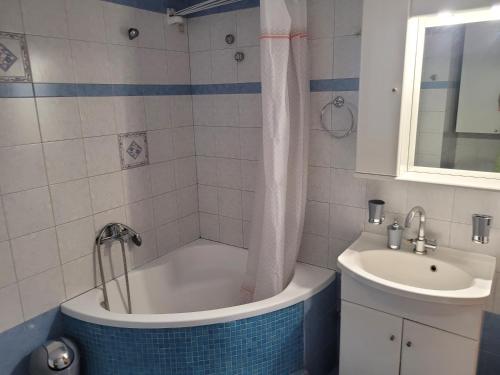 La salle de bains est pourvue d'une baignoire et d'un lavabo. dans l'établissement City Center Apartment, à Árta