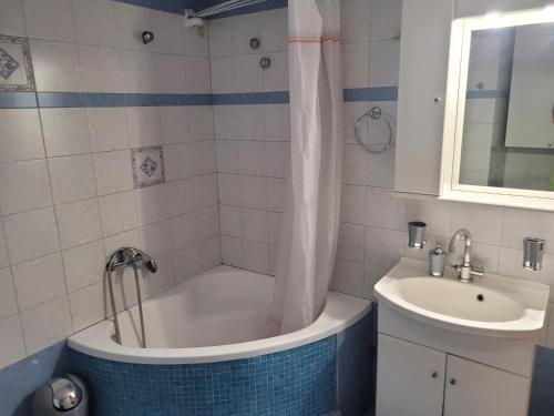 a bathroom with a tub and a sink at City Center Apartment in Arta