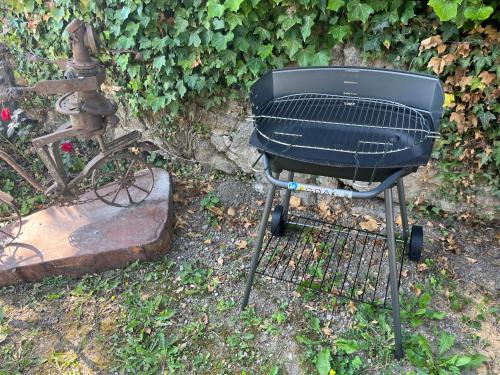 a grill sitting on the ground in a yard at Maison au pied du Château - L’Ange du Château in Champeix