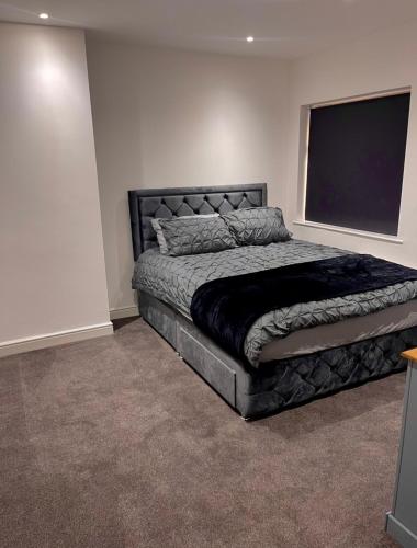 a bedroom with a large bed and a flat screen tv at Luxury 3 bedroom house -Private parking, sleeps 6, & featuring en-suite master bedroom in Birmingham