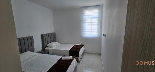 バジェドゥパルにあるDomus - Rio Guatapuri Panoramicのベッド2台と窓が備わる小さな客室です。