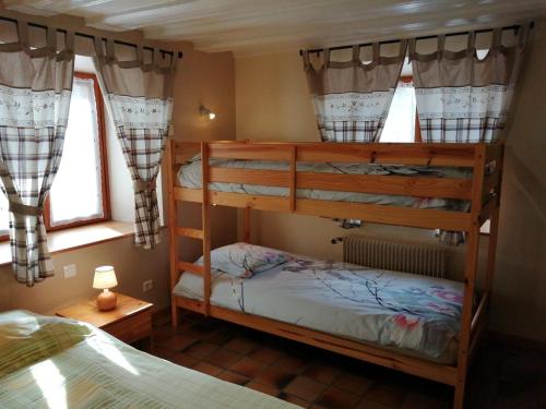 a bedroom with two bunk beds and two windows at Gîte au calme avec 2 chambres, terrasse, jardin, BBQ et parking inclus à Breitenbach-Haut-Rhin - FR-1-744-42 in Breitenbach-Haut-Rhin
