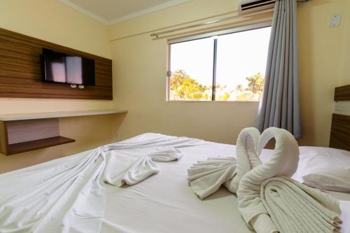 1 dormitorio con 1 cama con toallas en Lacqua Diroma Apartment, en Caldas Novas