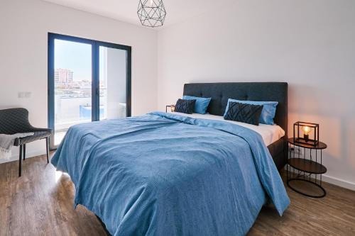 1 dormitorio con 1 cama grande con manta azul en Terraco Daniel, en Portimão