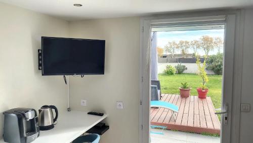 een kamer met een flatscreen-tv aan de muur bij Charmant Studio Cosy in Plaisance-du-Touch