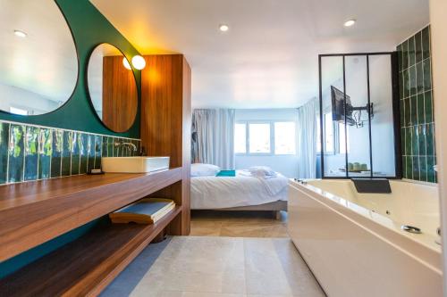 Love Room du Mont d'Or في مارسيليا: غرفة نوم بسرير ومرآة كبيرة