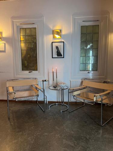 una habitación con 2 sillas y una mesa con velas en Ewa & Maude Hotel Aston Villa en Gotemburgo