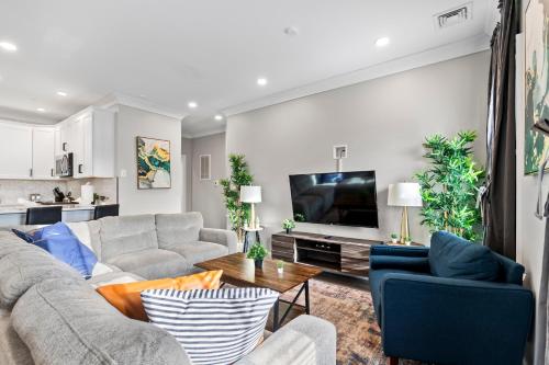 un soggiorno con divano e TV di Spacious Fully Furnished Apartment by Logan Airport a Boston