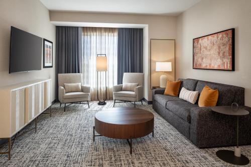 a living room with a couch and a table and chairs at Delta Hotels by Marriott Wichita Falls Convention Center in Wichita Falls