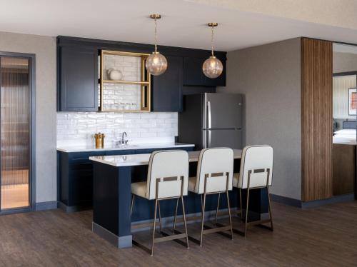 a kitchen with a blue counter and white stools at Delta Hotels by Marriott Wichita Falls Convention Center in Wichita Falls