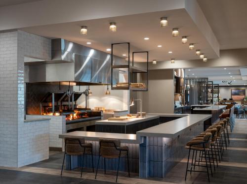 a kitchen with a bar with stools in it at Delta Hotels by Marriott Wichita Falls Convention Center in Wichita Falls