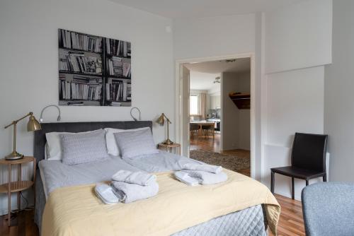 a bedroom with a bed with towels on it at Yellow Tower in Design District Helsinki, 1 bedroom apartment, top floor in Helsinki