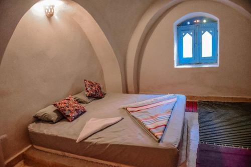 a bed in a room with an arched window at Khan tunis villa in Tunis