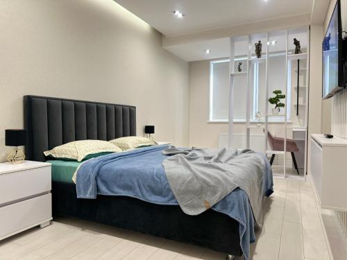 a bedroom with a bed with a black headboard at MODERN MINIMALIST APARTMENT Close to Airport and City Center. in Chişinău