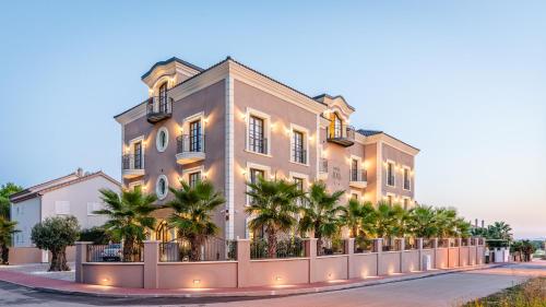 艾克許坦尼的住宿－Boutique Hotel Bora & Villas Garamm，一座棕榈树环绕的大建筑