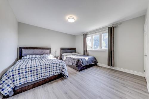 a bedroom with two beds and a window at Stunning 7 Br RougeView Home with 2 Kitchens, 5 Bathrooms, Amazing Backyard & 8-Car Parking in Toronto