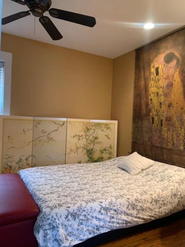 um quarto com uma cama e uma ventoinha de tecto em Oak Park Beauties - Tree Lined Streets - Walkable em Oak Park