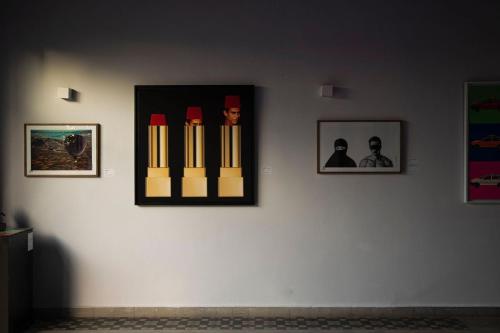 a wall with framed pictures on a white wall at Fellah Hotel in Marrakech