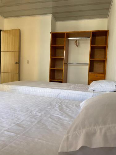sypialnia z 2 łóżkami i lodówką w obiekcie San Jorge VVC w mieście Villavicencio