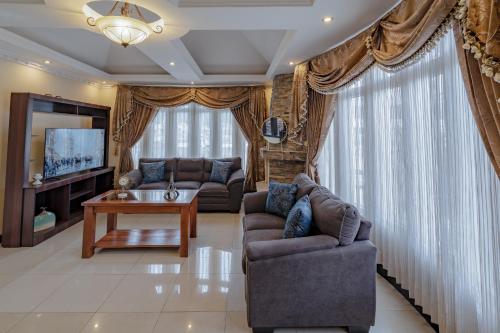 uma sala de estar com dois sofás e uma televisão em Amplia Casa Hogareña em El Adelanto
