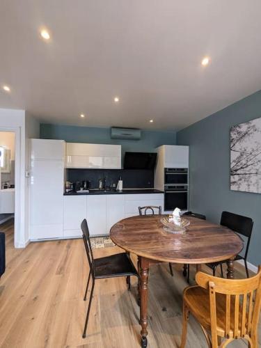 une cuisine et une salle à manger avec une table et des chaises en bois dans l'établissement La Villa Voie Verte, à Riorges