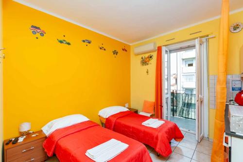 2 łóżka w pokoju z żółtymi ścianami w obiekcie Grotta dello Sport w Turynie