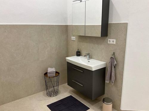 La salle de bains est pourvue d'un lavabo, d'un placard et d'un miroir. dans l'établissement Ruhe, Gesundheit und Aussicht, à Bad Liebenzell