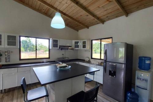 eine Küche mit einem Kühlschrank sowie einem Tisch und Stühlen in der Unterkunft Cabaña vista a las montañas de manabao in Manabao