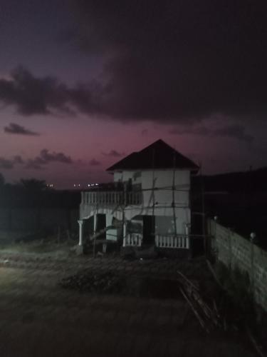 a white house with a porch at night at CIDMAT in Lakka