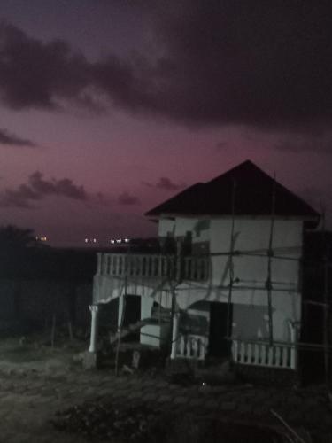 a white house at night with a dark sky at CIDMAT in Lakka