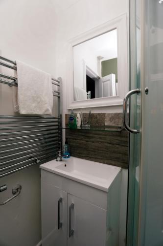 a bathroom with a sink and a mirror at Harmony Haven - Serenity Suite in Nottingham