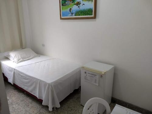a small room with a bed and a small refrigerator at Hotel Marajoara in Belém