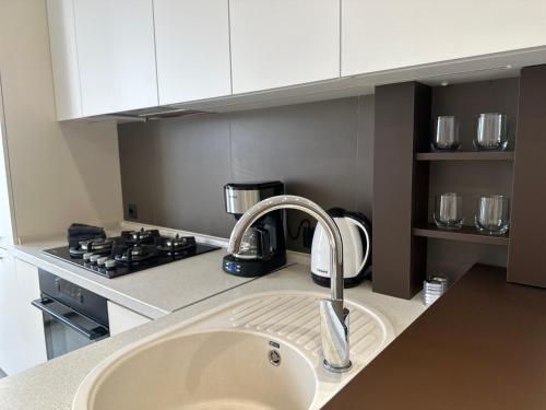 a kitchen counter with a sink and a stove at MODERN MINIMALIST APARTMENT Close to Airport and City Center. in Chişinău