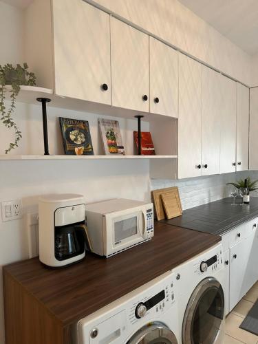 a kitchen with a washing machine and a microwave at L'Épicurien Limoilou "Central" in Quebec City
