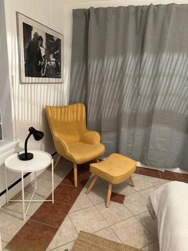 a bedroom with a chair and a table and a lamp at L'Épicurien Limoilou "Central" in Quebec City
