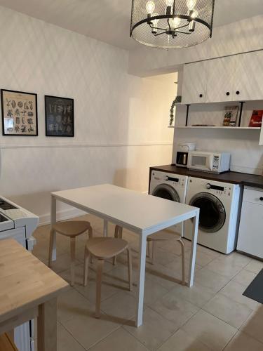 a kitchen with a white table and chairs and a washing machine at L'Épicurien Limoilou "Central" in Quebec City
