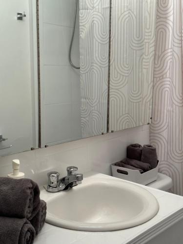 a bathroom with a white sink and a mirror at L'Épicurien Limoilou "Central" in Quebec City