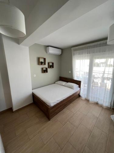 ein Schlafzimmer mit einem Bett und einem großen Fenster in der Unterkunft Happy Traveller SKG in Thessaloniki