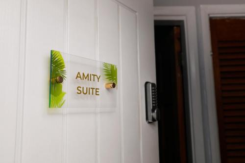 uma porta com um cartaz que lê qualquer suíte em Harmony Haven - Amity Suite em Nottingham