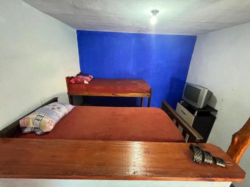 um pequeno quarto com uma cama e uma televisão em La Pintada Economy Class em Villa Dolores