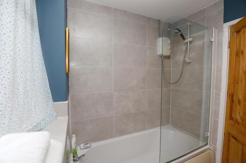 uma casa de banho com um chuveiro e uma porta de vidro em Harmony Haven - Amity Suite em Nottingham