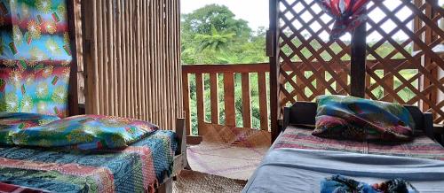 - un kiosque avec 2 lits et une fenêtre dans l'établissement Glowing Mountain view tree house, à Loanengo