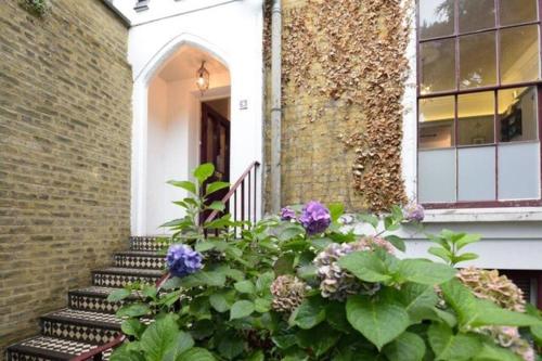 Eine Veranda mit einem Blumenstrauß neben einem Gebäude in der Unterkunft Spacious 4 bed, Central Camden in London