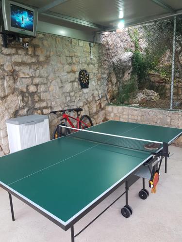 a ping pong table in a room with a stone wall at Apartments Villa Sonia & Teo Hvar in Hvar