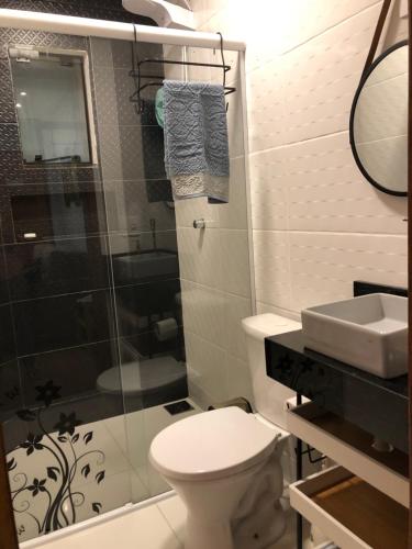 uma casa de banho com um WC, um chuveiro e um lavatório. em Loft aconchegante e funcional no Campeche em Florianópolis