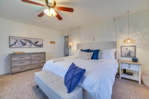 Un dormitorio con una cama blanca y un ventilador de techo. en Waterfront Lake City Home with Deck and Boat Dock!, en Lake City