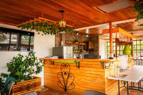 cocina con encimera de madera, mesa y sillas en Hotel La Floresta Salento, en Salento