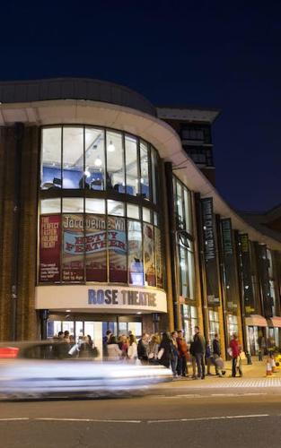 a building with people standing outside of it at night at Highfield Home with free parkings, Surbiton, Kingston upon Thames, Surrey, Greater London , UK in Surbiton