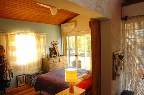 1 dormitorio con cama y ventana en Solar Diamantina Apartamentos, en Florianópolis